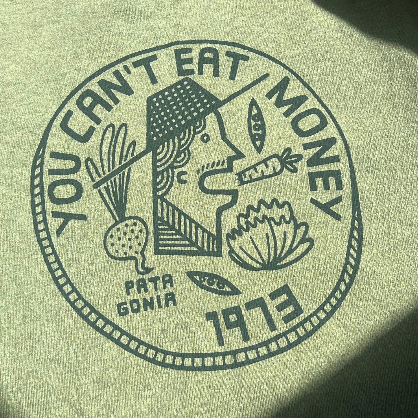 Army green t-shirt with "You Can't Eat Money" wordings and print of farmer
