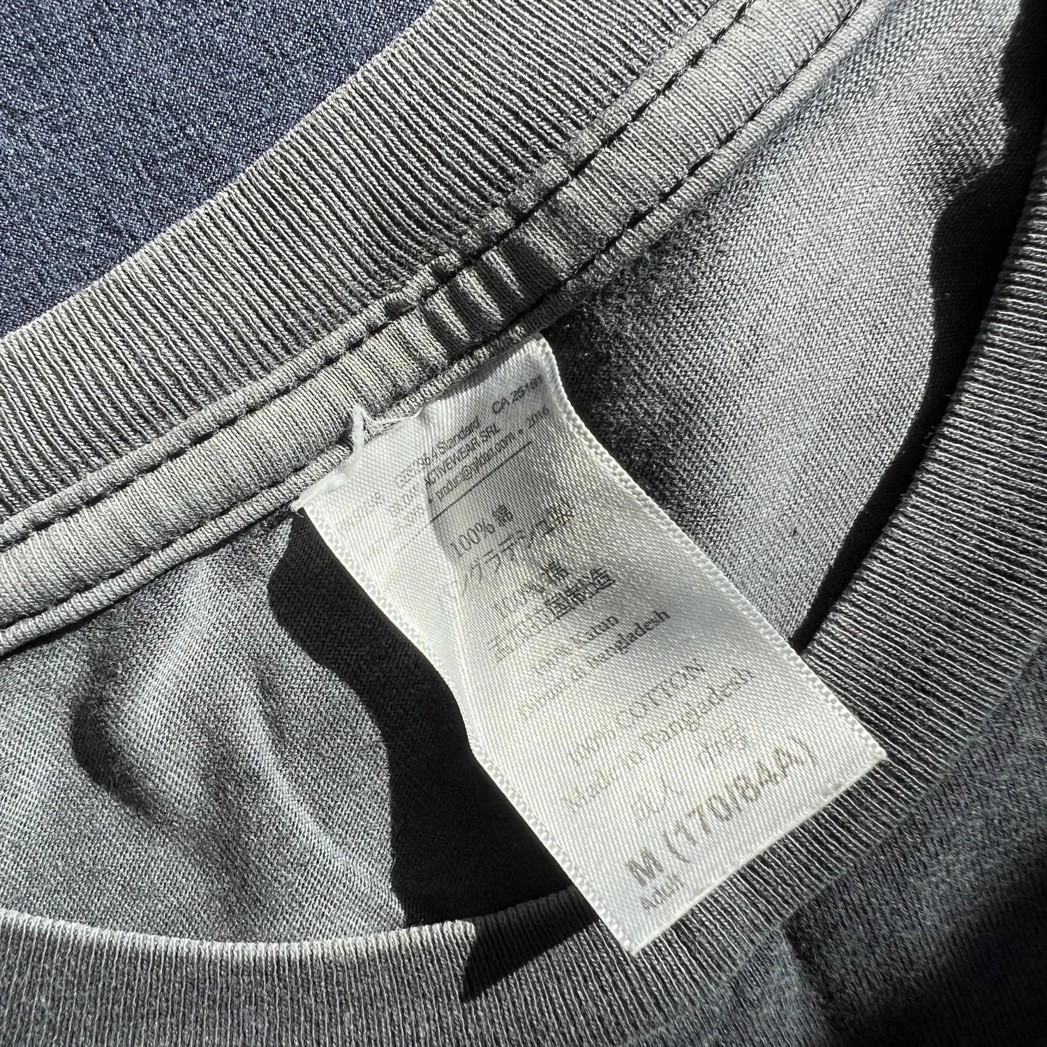 Black t-shirt with printed beer bottle design and text on a carelabel surface