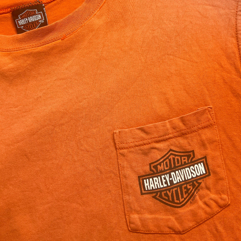 Orange sleeveless with Harley Davidson logo on chest pocket and a clothing neck label 