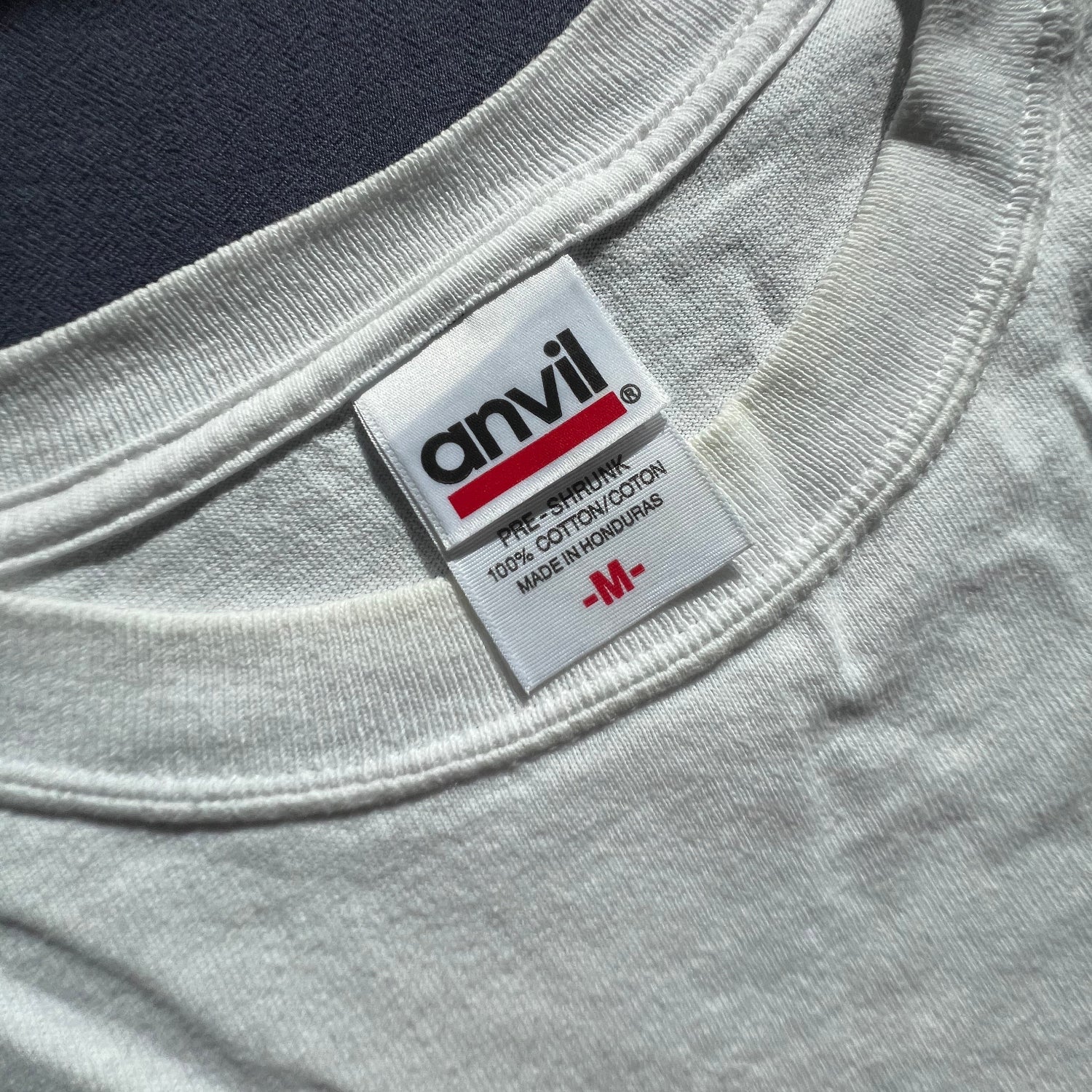 Close-up of an Anvil label on a white T-shirt